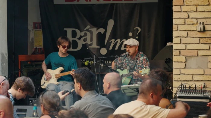 Zenekar játszik a szabadtéri színpadon a közönségnek